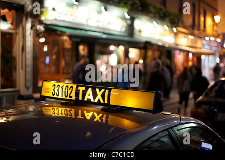 Taxi de nuit de Dublin avec des problèmes de mise au point s'allume en arrière-plan Banque D'Images