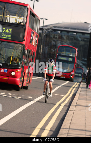 Un cycliste et deux bus traversant le pont de Westminster à Londres Banque D'Images