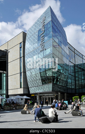 Les gens assis dans le centre commercial extérieur à l'entrée de John Grand magasin Lewis au centre commercial Westfield Stratford City est Londres Angleterre Royaume-Uni Banque D'Images