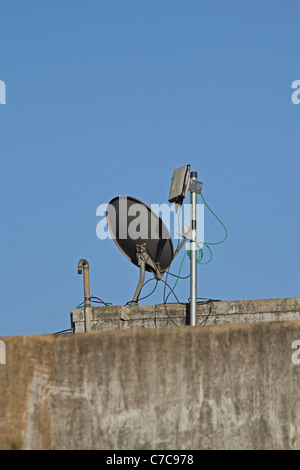 Antenne parabolique d'un poste de télévision sur une terrasse de l'immeuble, Pune, Maharashtra, Inde. Banque D'Images