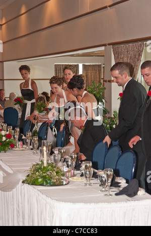 Mariée, mariée et invités de fête de mariage prenant place à la table pendant la réception de mariage photos images photos verticales aux États-Unis US haute résolution Banque D'Images