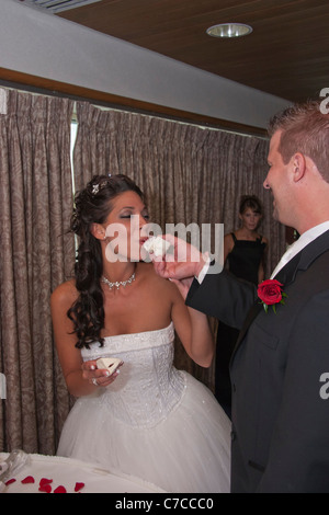 Un marié nourrissant un gâteau de mariée lors de la cérémonie de réception de mariage images photos photos aux États-Unis format vertical américain haute résolution Banque D'Images