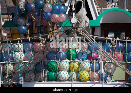 Flotteurs de différentes couleurs dans des filets sur un bateau de pêche dans le port de Padstow à Padstow, en Cornouailles, au Royaume-Uni, en mai Banque D'Images