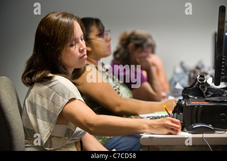 Les étudiants hispaniques de nombreux âges assister à une classe de base de l'ordinateur dans une bibliothèque publique à Santa Ana, CA. Banque D'Images