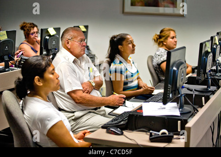 Les étudiants hispaniques de nombreux âges assister à une classe de base de l'ordinateur dans une bibliothèque publique à Santa Ana, CA. Banque D'Images