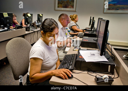 Les étudiants hispaniques de nombreux âges assister à une classe de base de l'ordinateur dans une bibliothèque publique à Santa Ana, CA. Banque D'Images