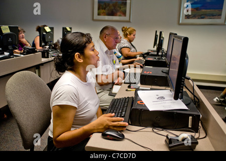 Les étudiants hispaniques de nombreux âges assister à une classe de base de l'ordinateur dans une bibliothèque publique à Santa Ana, CA. Banque D'Images