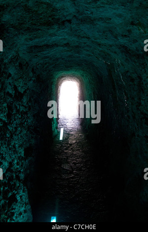 Tunnel grotte forme de voûte comme corridor sombre étroit avec la lumière loin Banque D'Images