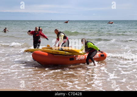 Les membres des équipes de sauvetage de la RNLI surfer sur la plage de Bournemouth England UK Banque D'Images