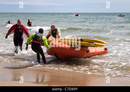 Les membres des équipes de sauvetage de la RNLI surfer sur la plage de Bournemouth England UK Banque D'Images