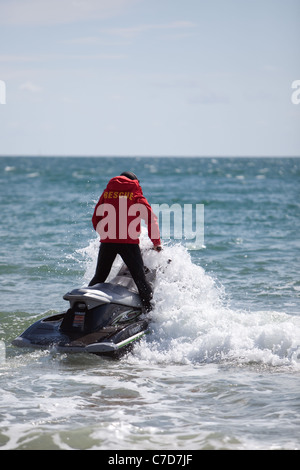 Des équipes de sauvetage de la RNLI surfer sur la plage de Bournemouth England UK Banque D'Images