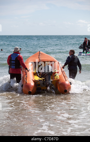 Des équipes de sauvetage de la RNLI surfer sur la plage de Bournemouth England UK Banque D'Images