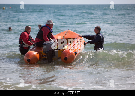 Des équipes de sauvetage de la RNLI surfer sur la plage de Bournemouth England UK Banque D'Images