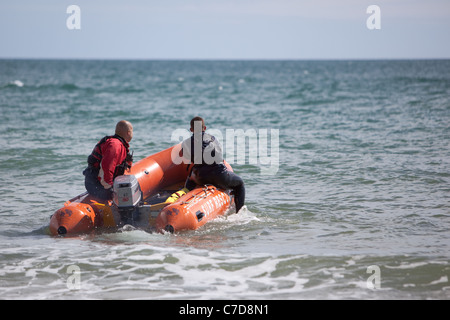 Des équipes de sauvetage de la RNLI surfer sur la plage de Bournemouth England UK Banque D'Images