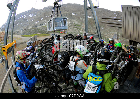 Riders en compétition dans l'Megavalnche course de vtt à l'Alpe d'Huez jusqu'à obtenir le téléphérique menant au sommet du Pic Blanc. Banque D'Images