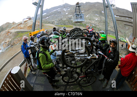 Riders en compétition dans l'Megavalnche course de vtt à l'Alpe d'Huez jusqu'à obtenir le téléphérique menant au sommet du Pic Blanc. Banque D'Images