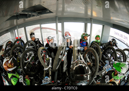 Riders en compétition dans l'Megavalnche course de vtt à l'Alpe d'Huez pack dans le téléphérique au sommet du Pic Blanc. Banque D'Images