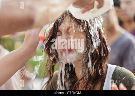 Femme chef thaïlandais éclaboussé avec de l'eau au cours de chanson kran festival du Nouvel An bouddhiste à Silom Road, Bangkok, Thaïlande Banque D'Images