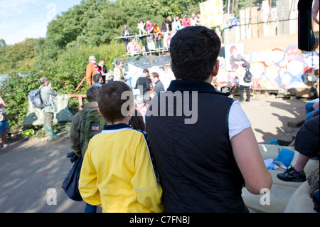 Deux enfants de nomades de Dale Farm regardez sur les médias et les partisans de l'attente des voyageurs par la porte au site pour les huissiers. Banque D'Images