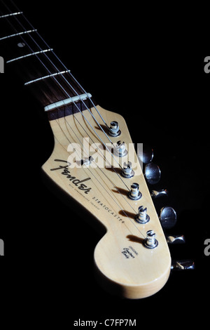 Guitare fender stratocaster personnalisées de frette et chef éclairé avec lumière directionnelle sur fond noir. Banque D'Images