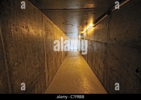 Tunnel avec murs en acier menant à la lumière Banque D'Images