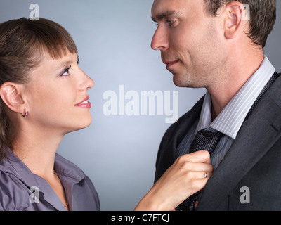 Jeune femme ajustant son mari cravate Banque D'Images