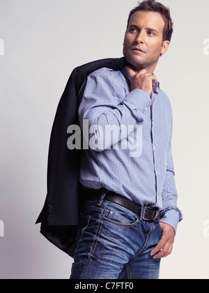 Style décontracté avec habillé homme dans la trentaine avec une veste par-dessus son épaule Banque D'Images