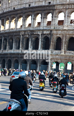 Scooter et charge les motards vers le Colisée à Rome. Banque D'Images