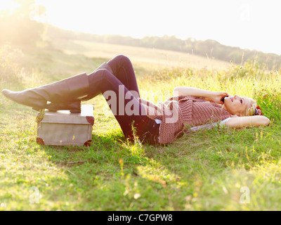 Une femme allongée dans l'herbe à l'aide d'un téléphone mobile Banque D'Images