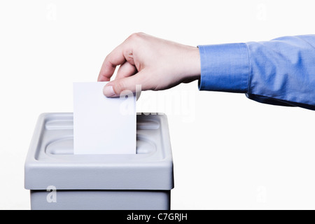 Un homme de mettre un bulletin blanc dans une boîte de scrutin, close-up hands Banque D'Images