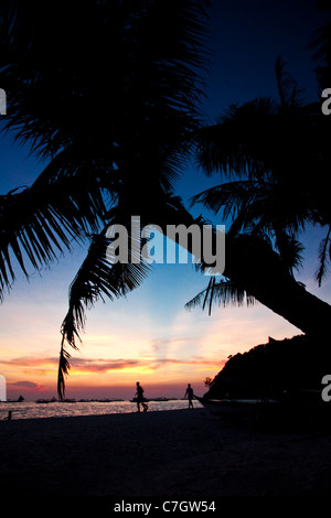 Scène de plage tropicale aux couleurs brillantes persistantes silhouetté contre le ciel au coucher du soleil sur l'île de Boracay, Philippines. Banque D'Images