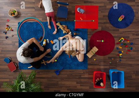 Une famille de jouer avec des jouets dans leur salon, overhead view Banque D'Images