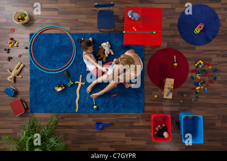 Une mère et sa fille jouant avec des jouets dans un salon, vue aérienne Banque D'Images