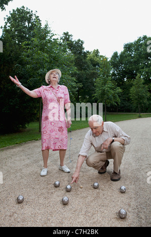Les cadres supérieurs l'homme et la femme ont litige boulodrome dans le parc Banque D'Images