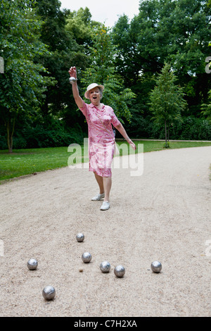 Hauts femme joue aux boules dans le parc Banque D'Images