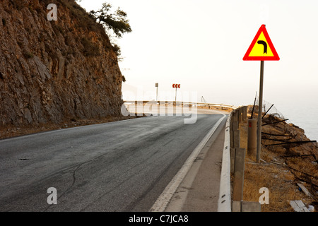 Signe indique virage à gauche sur la route de falaise sur Kefalonia Banque D'Images