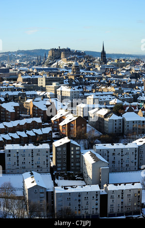 Le Château d'Édimbourg et sur les toits de la ville dans la neige avec Dumbiedykes au premier plan de Salisbury Crags, Édimbourg, Écosse Banque D'Images