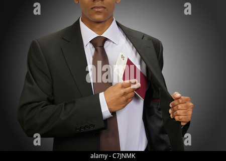 Businessman putting passeport en poche Banque D'Images