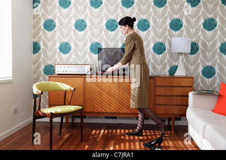 Femme en robe vintage playing records Banque D'Images
