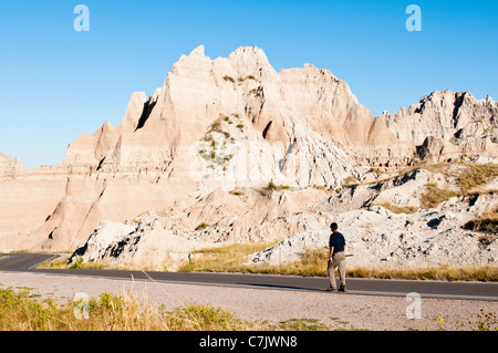 Un randonneur promenades le long de la pittoresque route en boucle Badlands Badlands National Park dans le Dakota du Sud. Banque D'Images