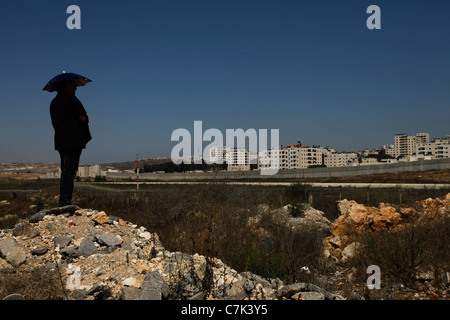 Regarder un civil israélien Cisjordanie barrière de séparation divisant la ville palestinienne de Ramallah à partir de la région de Jérusalem en Cisjordanie Israël Banque D'Images