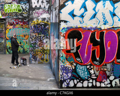 Graffitis en terre sur la rive sud, Londres- man spraying wall 2 Banque D'Images