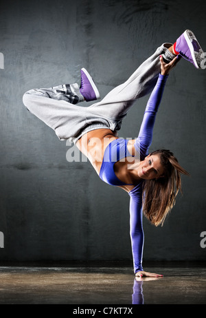 Jeune femme danseuse sur fond de mur. Banque D'Images