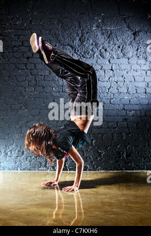 Jeune femme danseuse sur fond de mur. Banque D'Images