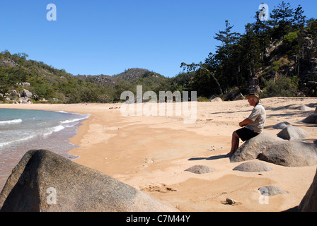 Homme assis sur tour surplombant la mer, Arthur bay, Magnetic island, Townsville, Queensland, Australie Banque D'Images