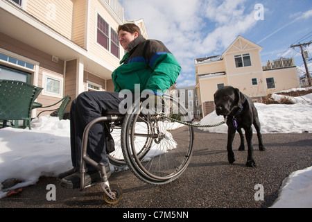 Femme avec la sclérose en plaques dans un fauteuil roulant avec un chien Banque D'Images