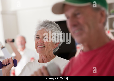 Les personnes âgées l'entraînement avec haltères en un club de santé Banque D'Images