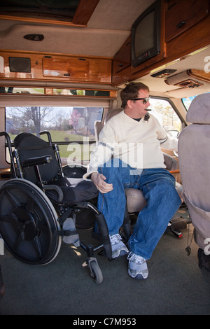 L'homme avec la moelle épinière d'entrer dans le siège du conducteur, de son fauteuil roulant en fourgonnette accessible Banque D'Images