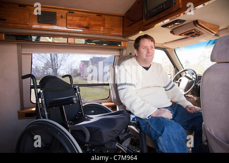 L'homme avec la moelle épinière d'entrer dans le siège du conducteur, de son fauteuil roulant en fourgonnette accessible Banque D'Images