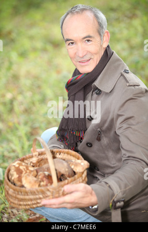 Homme cueillette de champignons dans la forêt Banque D'Images